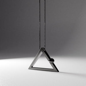 Yoga inspired rhodium plated silver necklace. The jewel stylises the Lotus pose in an essential and geometric way. It represent the Adho Mukha or dog pose and is represented by a triangle. Sliding pendant.