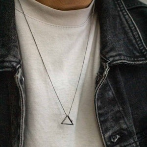 Yoga inspired rhodium necklace. The jewel stylises the Adho Mukha pose in an essential and geometric way. Sliding pendant. Man jewel
