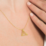Yoga inspired gold necklace. The jewel stylises the Padmasana pose in an essential and geometric way. Sliding pendant.