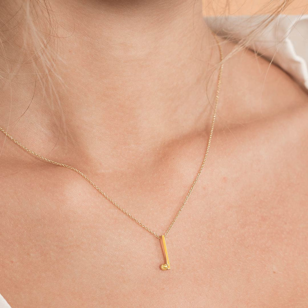 Yoga inspired gold necklace. The jewel stylises Sirsasana pose in an essential and geometric way. Sliding pendant.