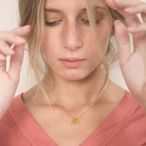 Yoga inspired gold necklace. The jewel represents the triangle pose. Essential and geometric style. Sliding pendant.
