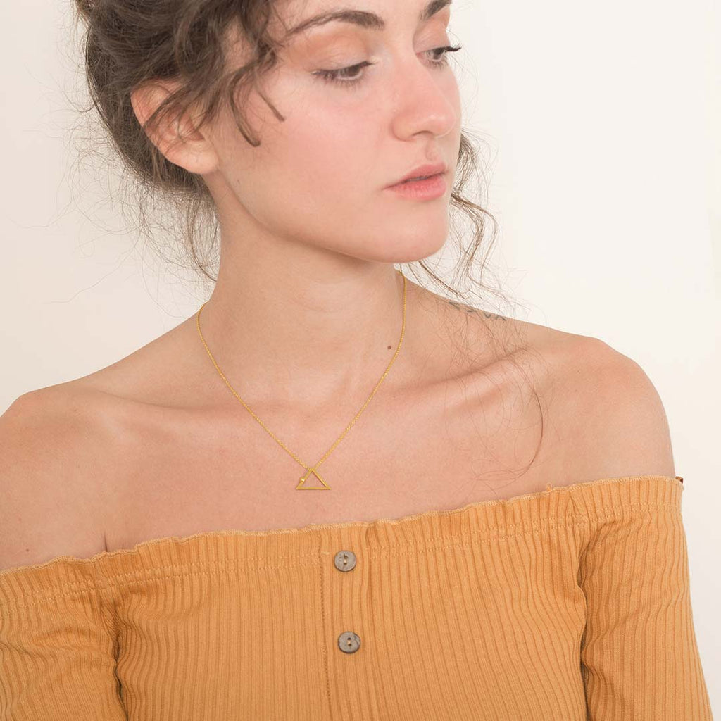 Yoga inspired gold necklace. The jewel represents the downward dog position. Essential and geometric style. Sliding pendant.
