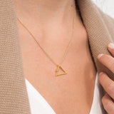 Yoga inspired gold necklace. The jewel stylises the Adho Mukha pose in an essential and geometric way. Sliding pendant.